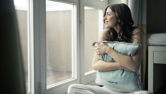 a woman waiting to get tan through a window