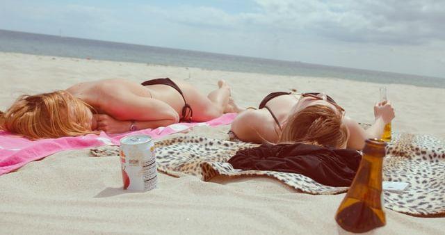 Two Women Sunbathing on the beach in the morning