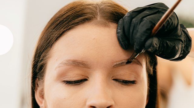 a woman is getting microbladed eyebrows