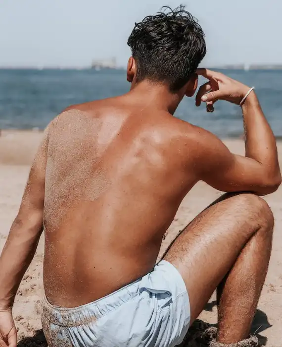a-shirtless-man-sitting-on-the-sand