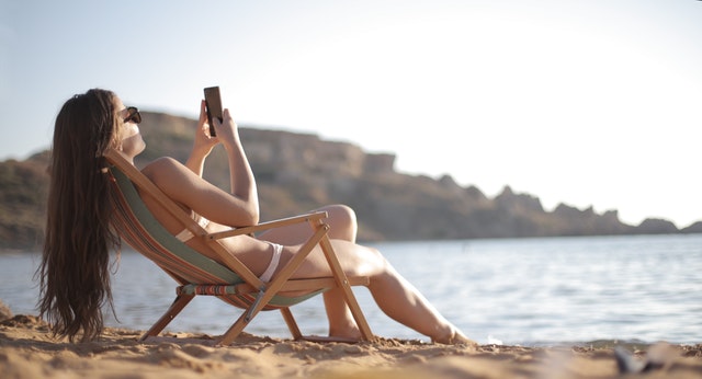 Woman using digital phone on the sunbed