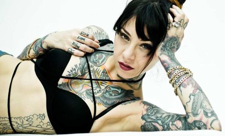 cropped view of a beautiful tattooed girl lying on the bed